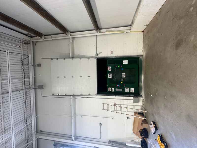 Commercial insulated sectional door half open with opener visible in MA warehouse