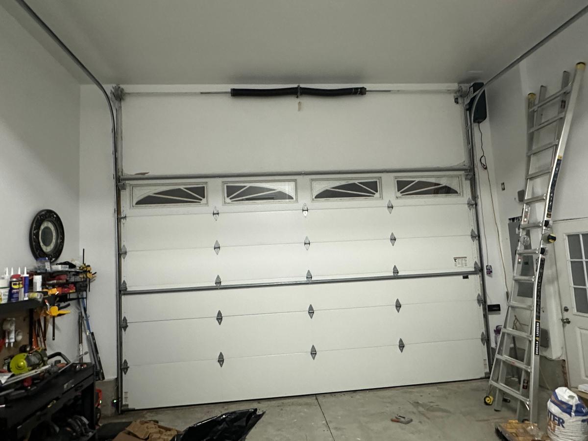 Completed white double garage door with decorative top windows — Massachusetts residential